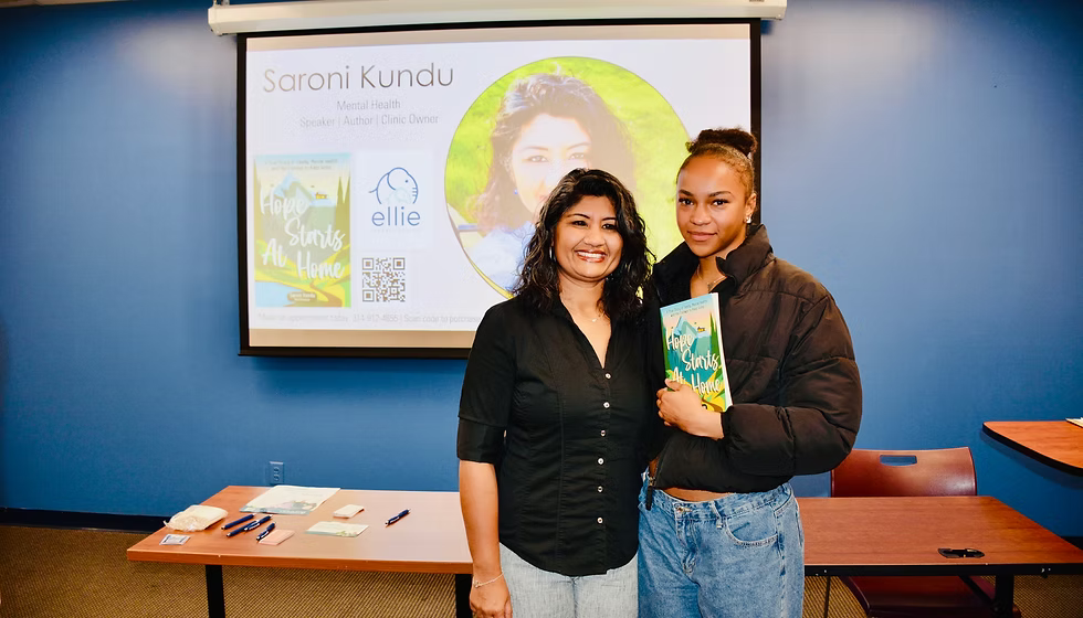 Saroni Kundu presenting her book alongside an attendee at a speaking event
