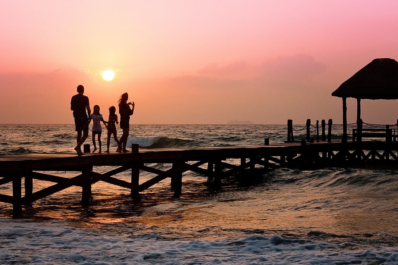 Happy family standing together at sunset