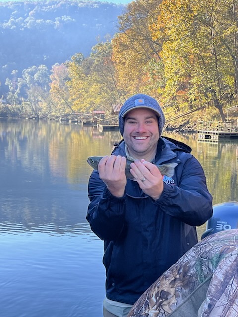 Large brown trout being held by angler in clear river water
