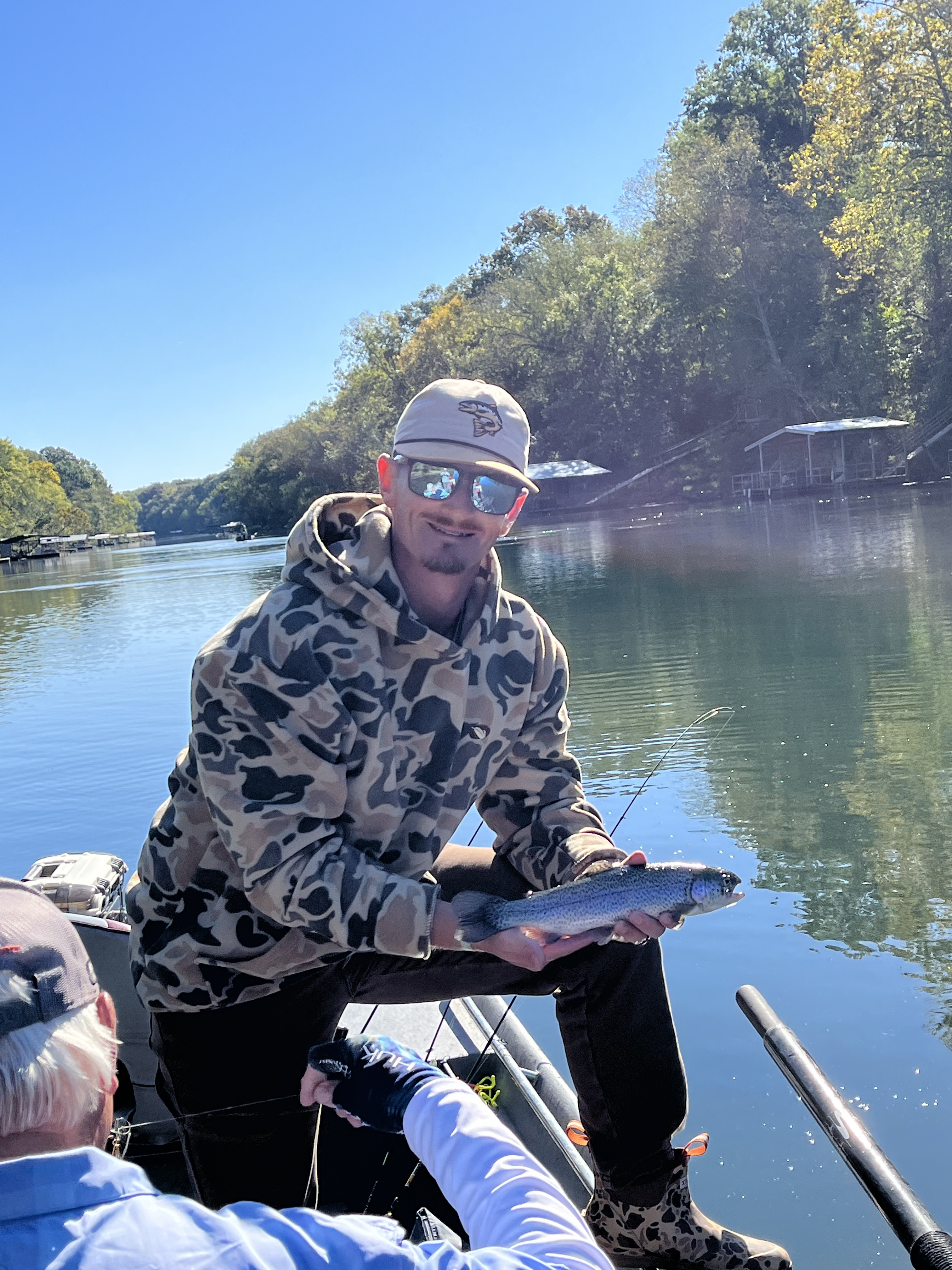 Drift boat on calm river with forested banks in Arkansas