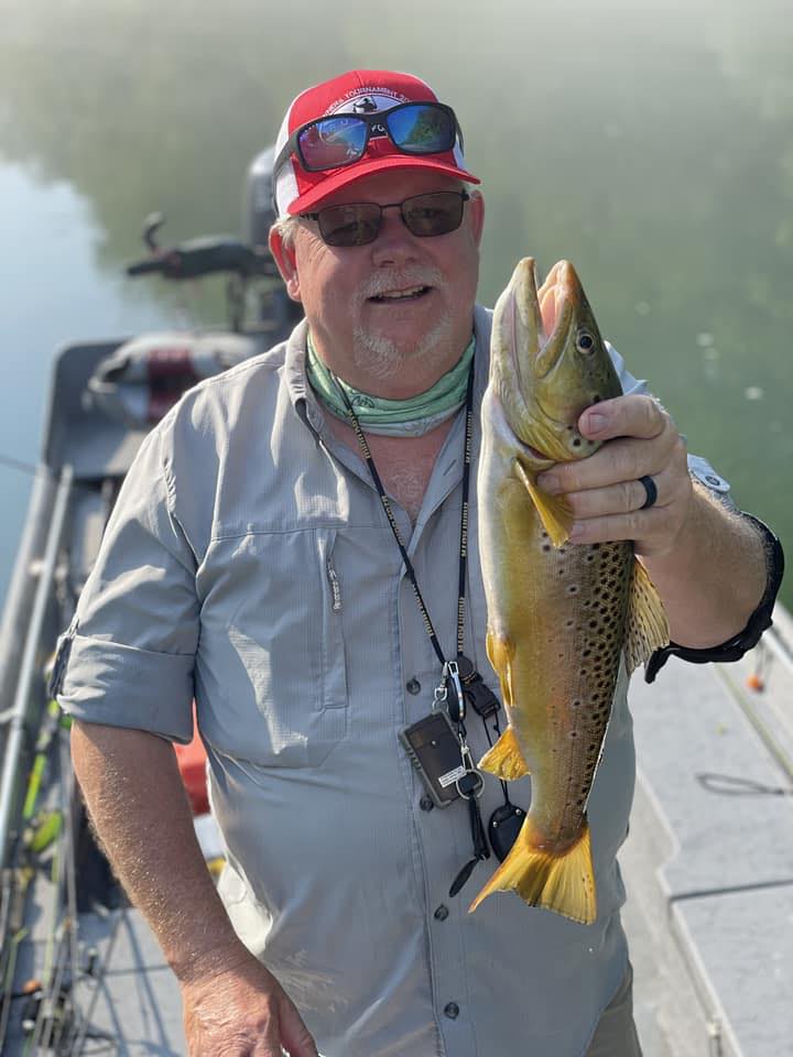 Trophy brown trout being held by guide on the Little Red River in Arkansas