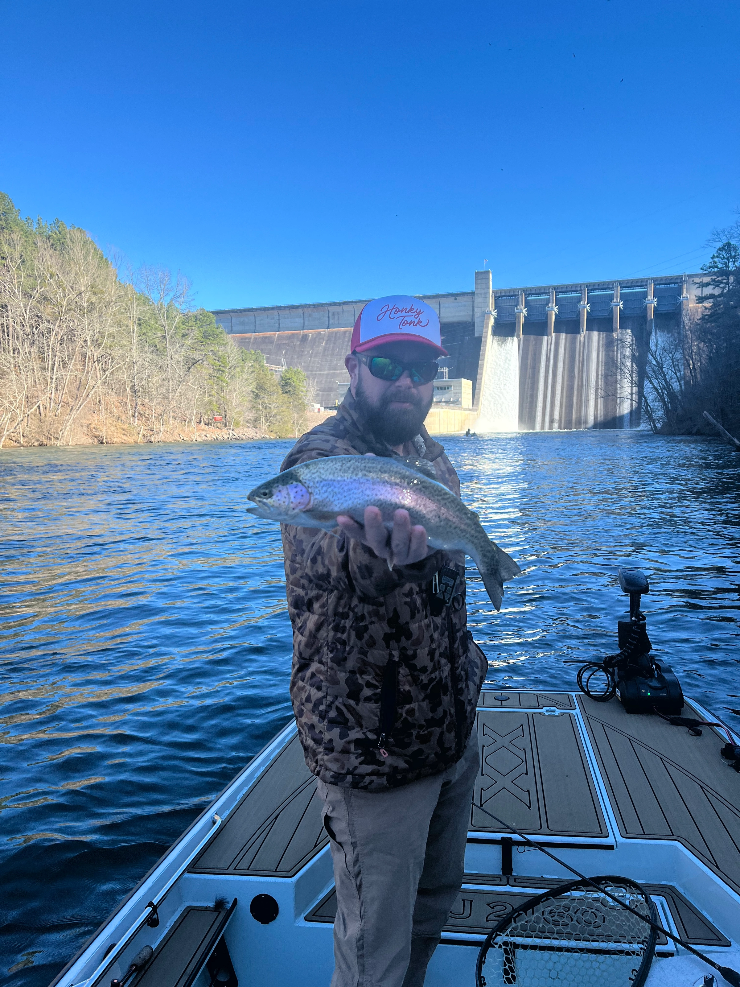 Fly fisherman wading in river during morning session with guide