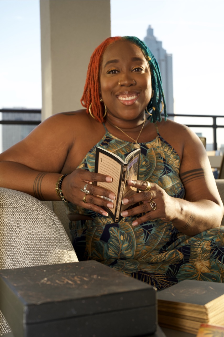 Tanisha Yorrick smiling while holding a book