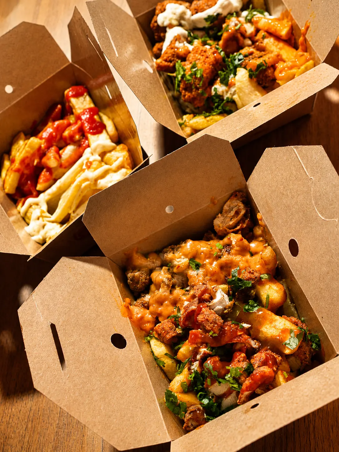Selection of loaded CHIPZ London chips topped with chicken, sauces and fresh herbs