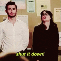 GIF: "Shut it down" Jess from New Girl starts with her arms crossed at her chest then stretches them out and down. You can just barely see the facial expression of the guy next to her because she hits him in the privates in the process.