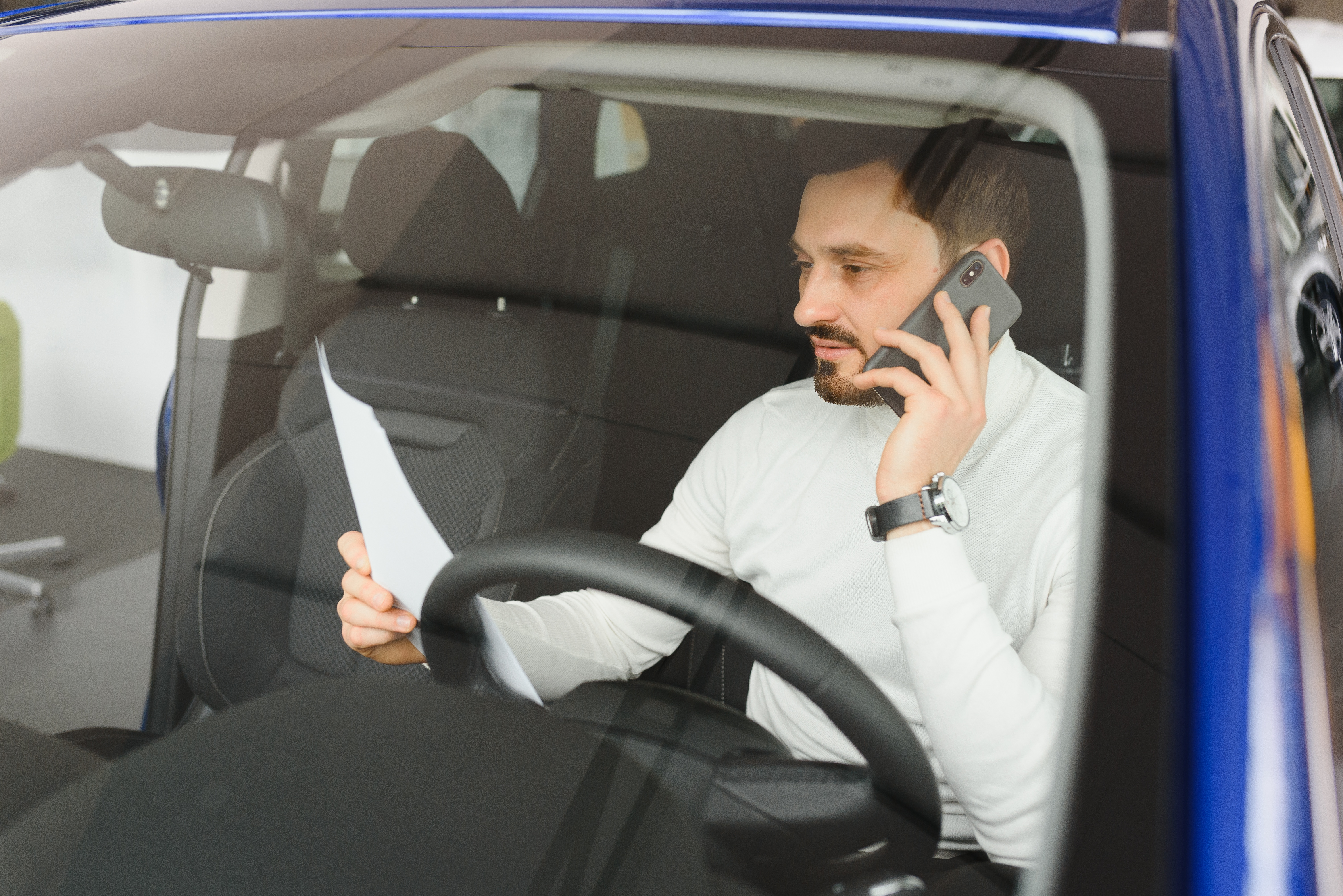 empresario que usa un teléfono inteligente móvil en el automóvil