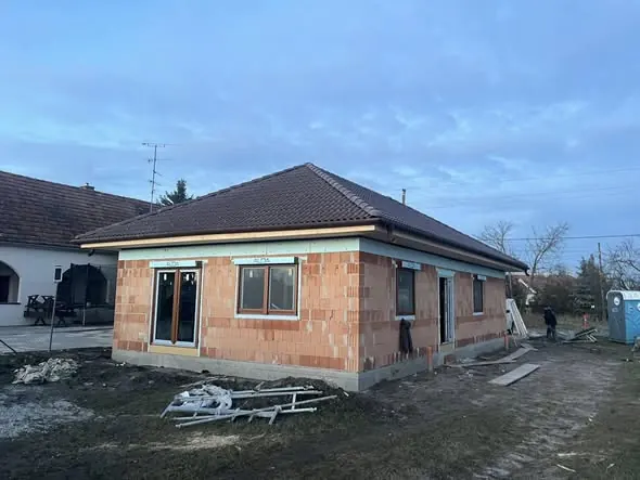 Győr városában, a Farkas-Konstrukt Kft. generálkivitelezési projektjének részeként egy új építésű ház látható, amely még befejezés előtt áll. A ház téglából készült, és új ablakkeretek kerültek beépítésre. A környezet rendezett, a munkálatok folyamatban vannak, a területen építőipari eszközök és anyagok találhatóak.