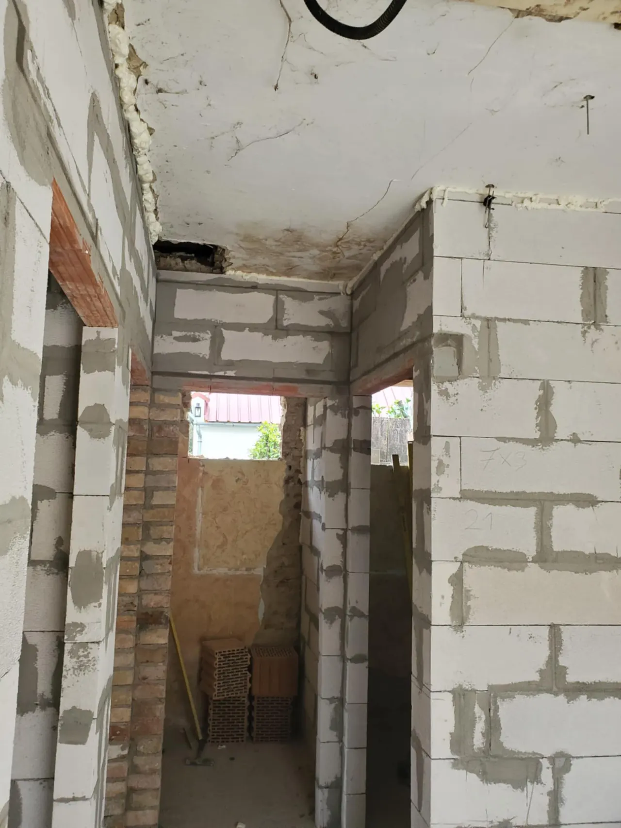 A képen egy építkezési terület látható Ajkán, ahol a generálkivitelezés munkálatai zajlanak. A falak még nem készültek el teljesen, láthatóak a téglák és a friss vakolat. Az épület belsejében a mennyezet is felújításra szorul, ami a munkálatok előrehaladását tükrözi. Farkas-Konstrukt Kft. által végzett kivitelezési munka nyomai jól láthatók.