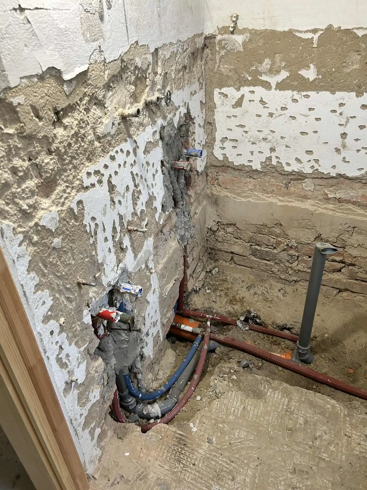 A képen egy fürdőszoba felújításának előkészületei láthatók, ahol a falak részben lebontva, a csővezetékek pedig előkészítve állnak. A területen láthatóak a víz- és fűtéscsövek, amelyek szakszerűen vannak elhelyezve. A Farkas-Konstrukt Kft. Generálkivitelezés szolgáltatása Győr városában biztosítja a minőségi felújítást, amely elősegíti a fürdőszoba korszerűsítését.