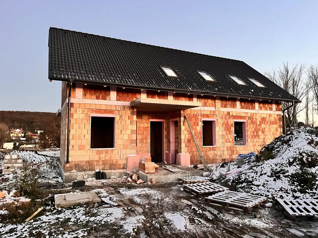 Új építésű családi ház látható Győr városában, amelyet a Farkas-Konstrukt Kft. generálkivitelezés keretében valósít meg. Az épület még befejezés előtt áll, a falak részben burkolva, a tető fekete cseréppel fedve. A ház előtt építőanyagok és munkagépek találhatók, a környezetben hó és építkezési hulladék látható.