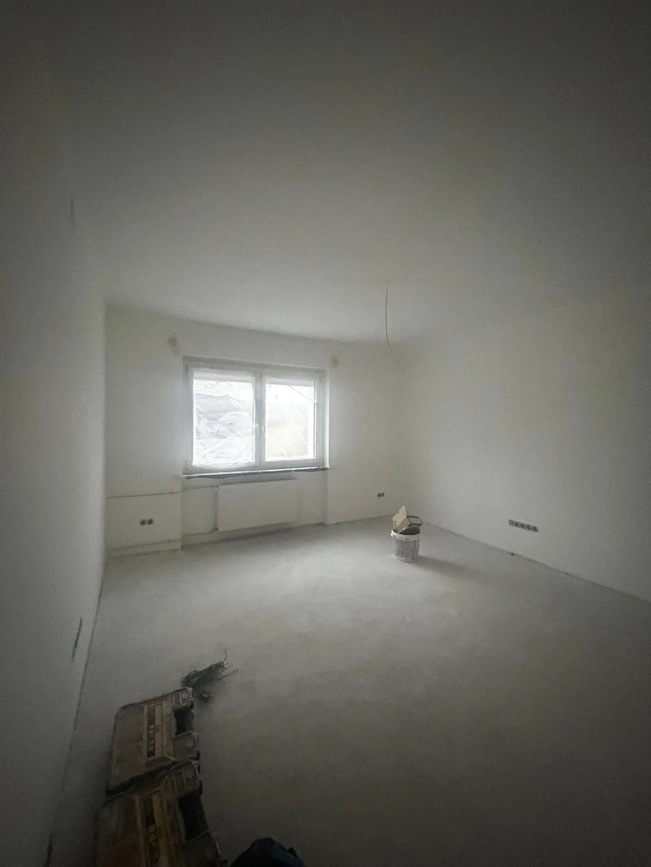 Egy üres, világos szobát látunk, amelynek falai simák és fehérek, a padló pedig szürke szőnyeggel borított. A szoba közepén egy kosár található, míg az ablak mögött természetes fény áramlik be. A háttérben látható egy fűtőtest is. Sopron városában a Farkas-Konstrukt Kft. generálkivitelezési szolgáltatásait tükrözi az image, amely a modern belső terek kialakítására fókuszál.