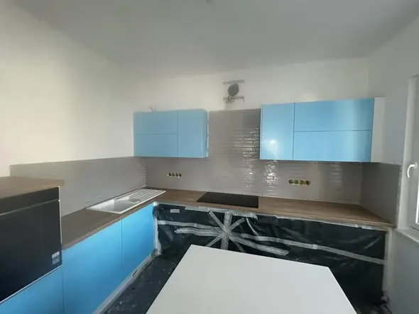 Modern konyha Szombathelyen, a Farkas-Konstrukt Kft. generálkivitelezési projektjének részeként. Az elegáns, világoskék szekrények és a világos, letisztult design stílusos megjelenést kölcsönöznek a térnek. A konyhapult mellett egy fehér asztal található, amely ideális étkezésekhez. Az alapanyagok és a kivitelezés minősége tükrözi a cég szakértelmét a generálkivitelezés terén.