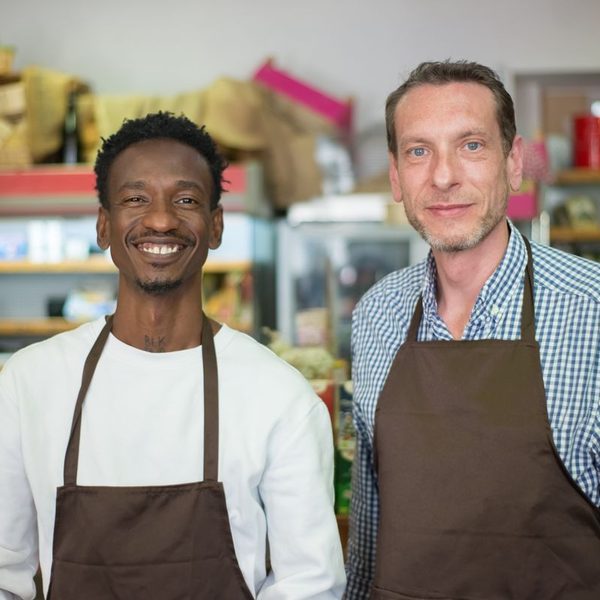 Two grocery store owners smiling