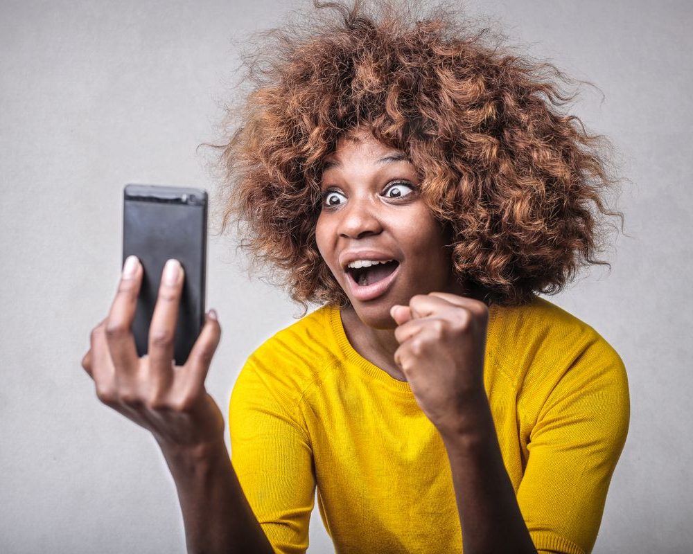 Woman excited by good news on her phone
