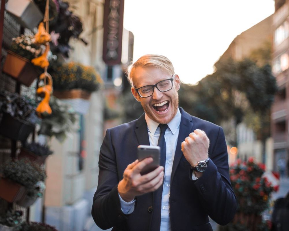 Business owner celebrating an approval on his phone