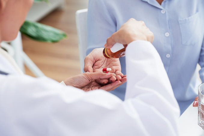 hands-unrecognizable-female-doctor-giving-pills-patient