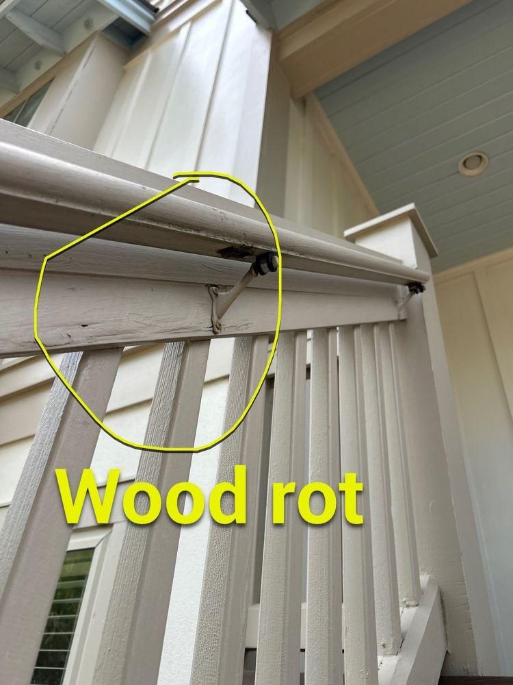 Exterior painted wooden handrail assembly with visible wood rot circled in yellow at a structural connection point