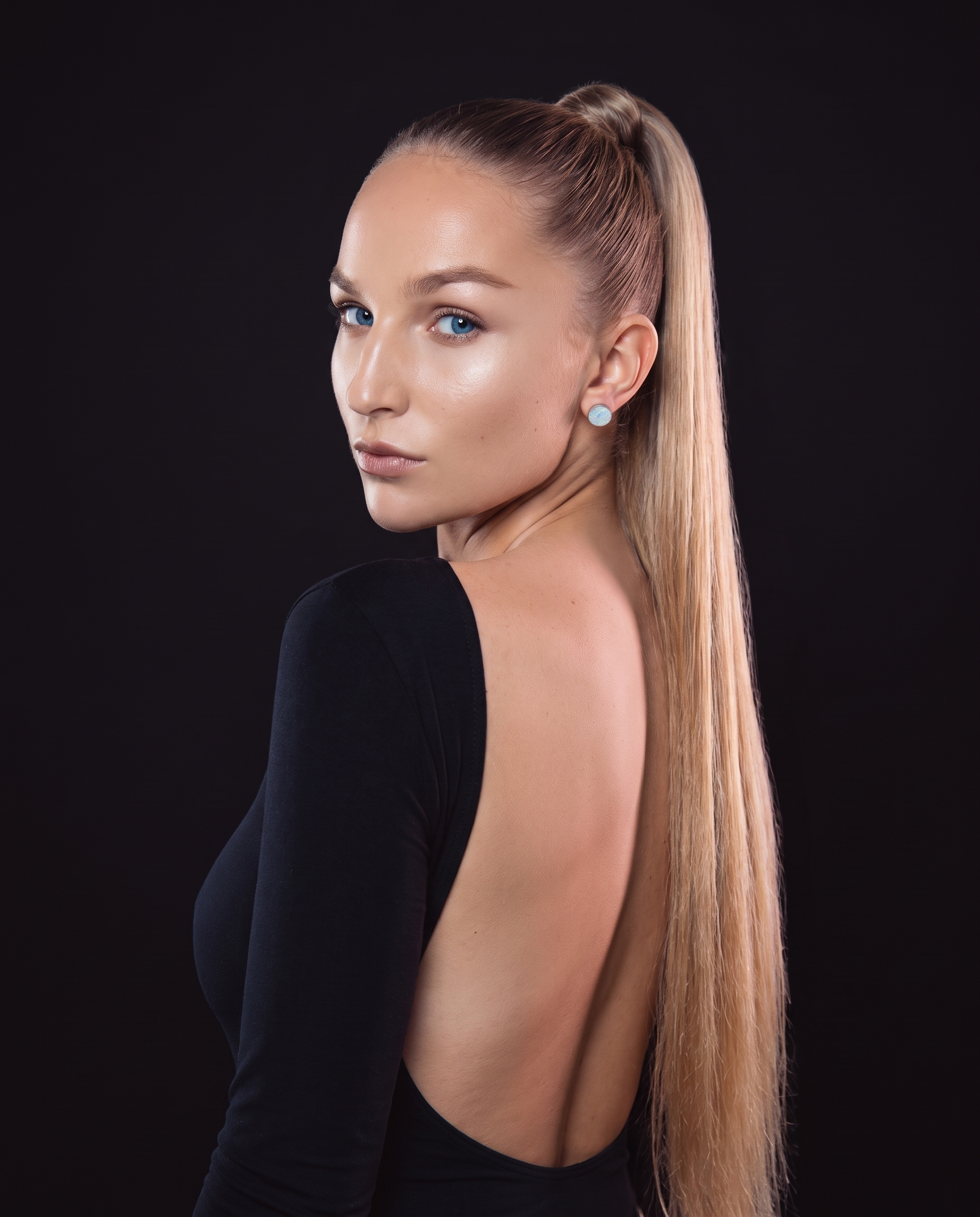 Nova glancing over her shoulder in a dark studio