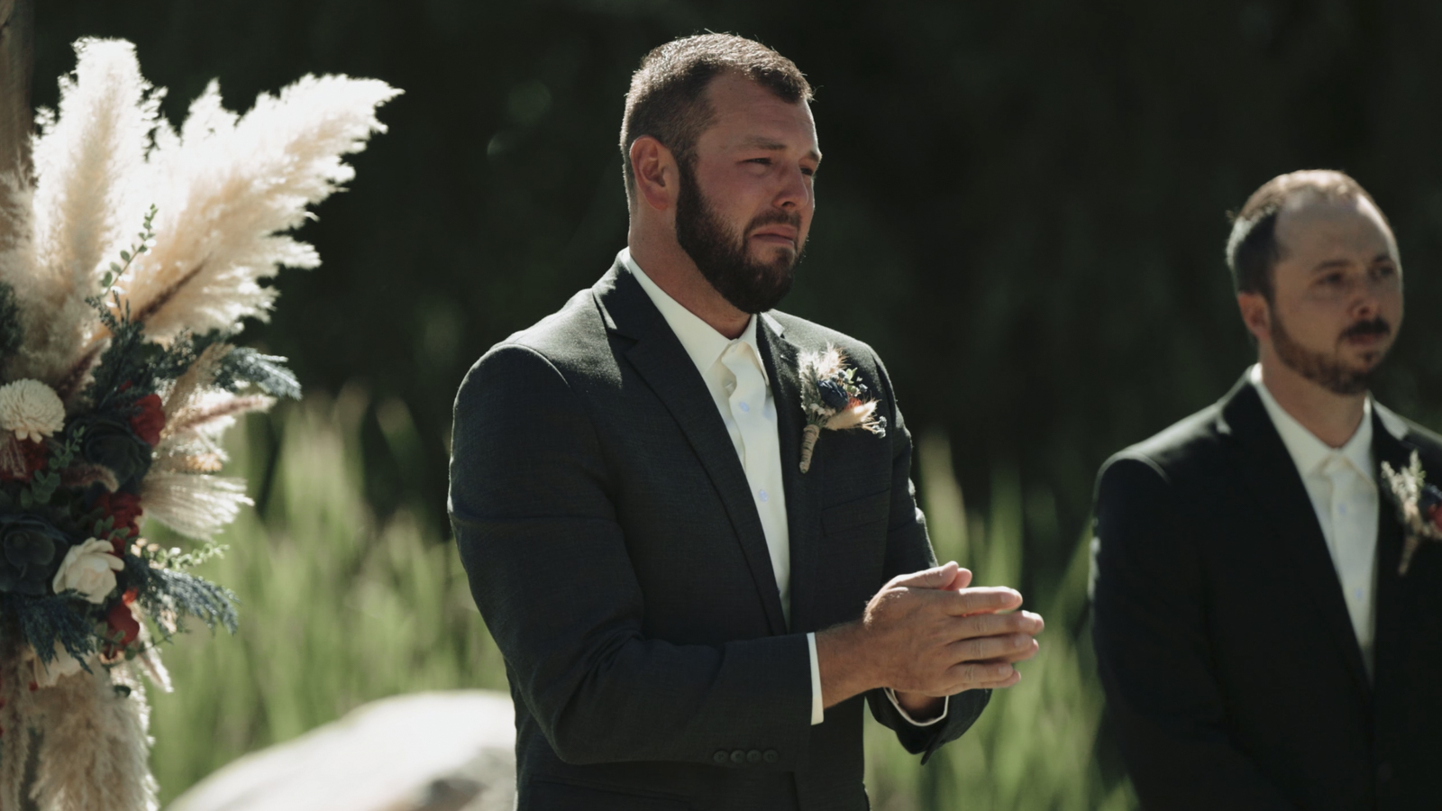 A groom watching his bride arrive at the ceremony