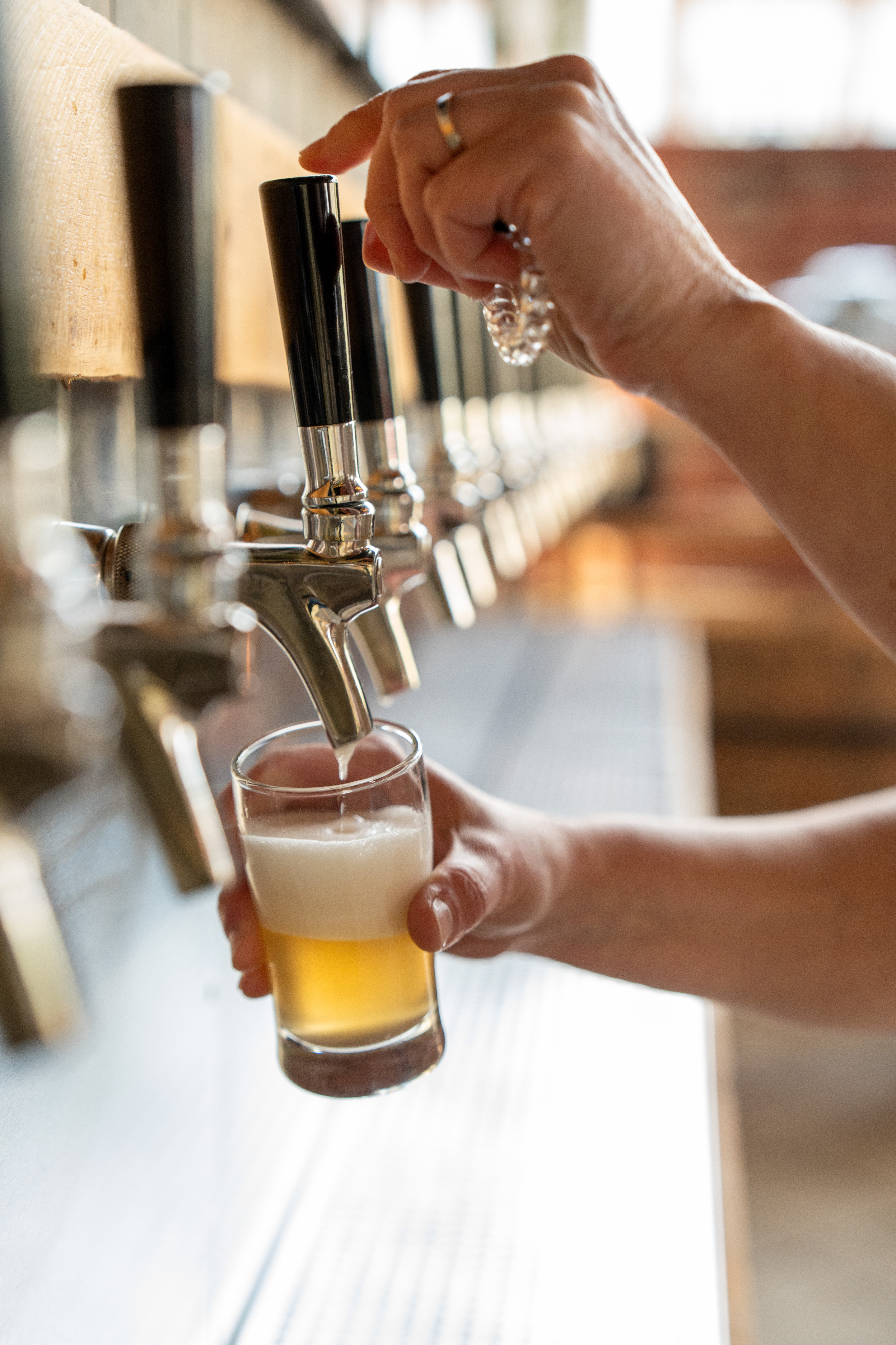 Pouring a beer from the self-pour wall at Hold My Beer Kenosha