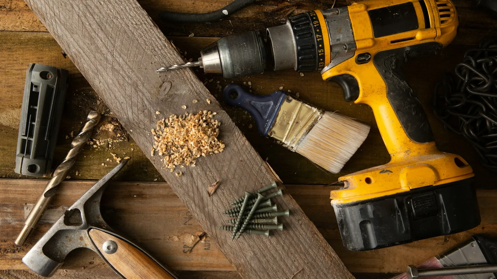 Cordless drill, hammer and hand tools on a workbench