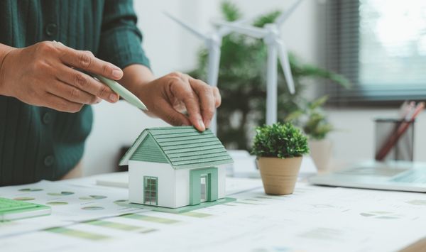 Sustainable home planning concept with model house and wind turbine for energy-efficient ADU construction