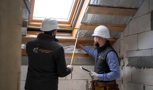 CTINY Homes team reviewing measurements during ADU construction in Connecticut.
