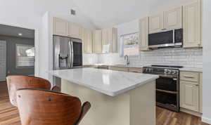 Finished Connecticut ADU kitchen with cream cabinets, stainless steel appliances, and storage island Finished Connecticut ADU kitchen with cream cabinets, stainless steel appliances, and storage island