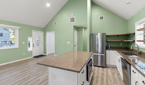 Open ADU kitchen in Connecticut with island, stainless steel appliances, vaulted ceiling, and living space