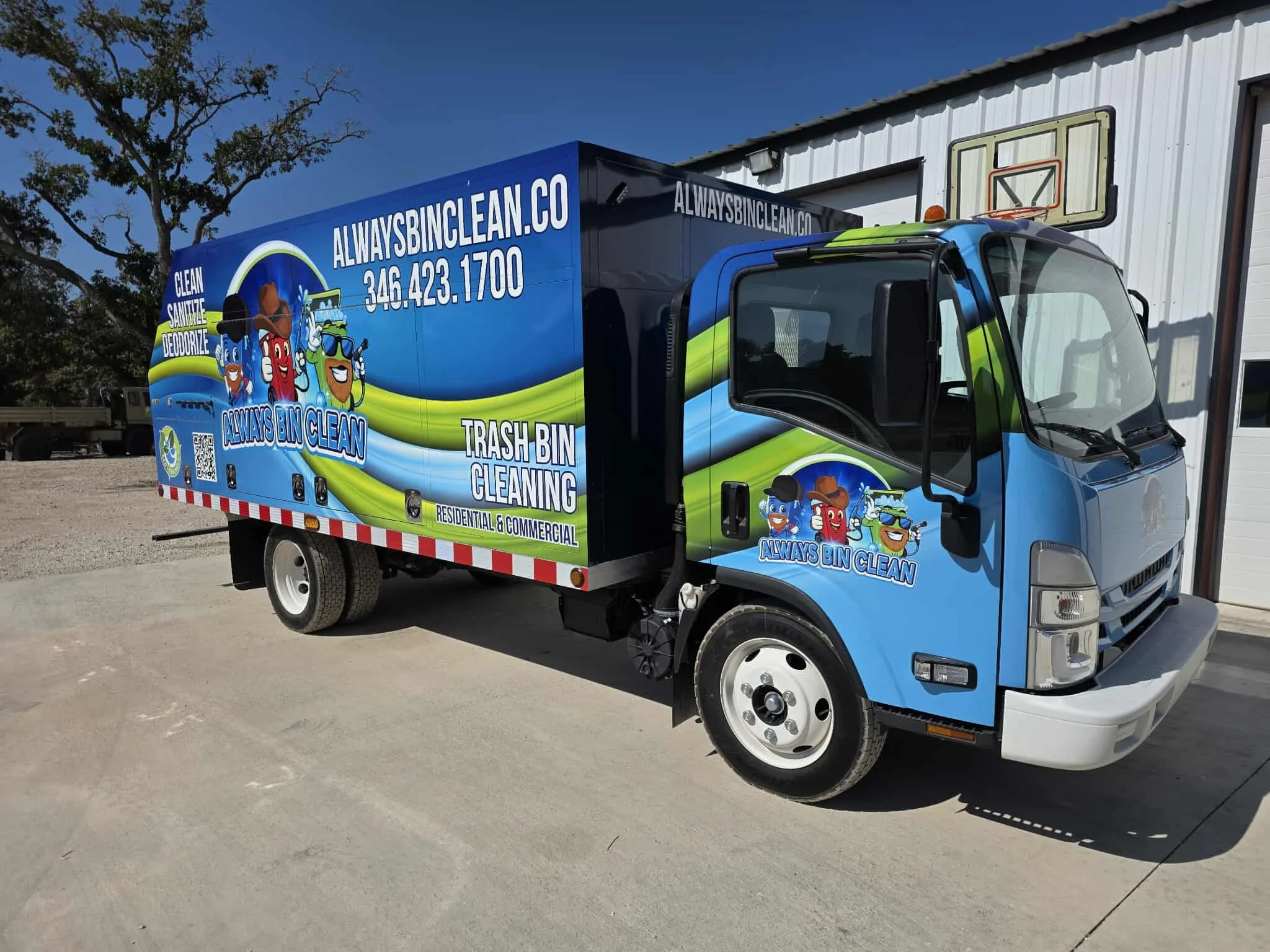 A brightly branded 'Always Bin Clean' trash bin cleaning truck parked outdoors, displaying cartoon mascots and service details.