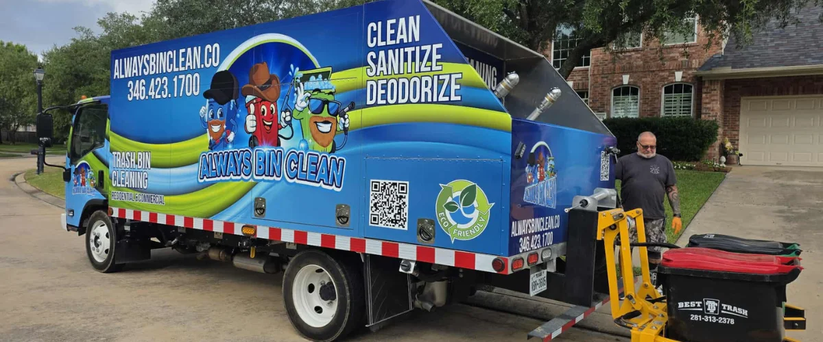 A brightly colored blue and green "Always Bin Clean" truck with a worker cleaning trash bins in front of a house.
