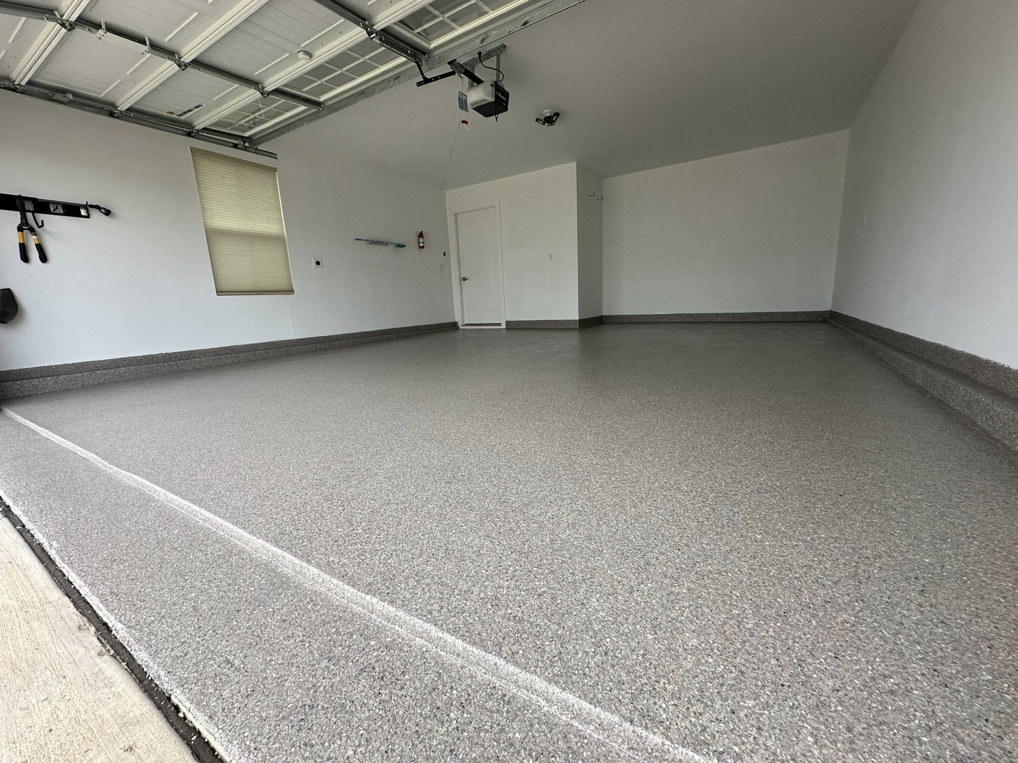 close-up of a gray, white, and black flake garage floor in a cool shadows color palette, showing subtle texture and gloss