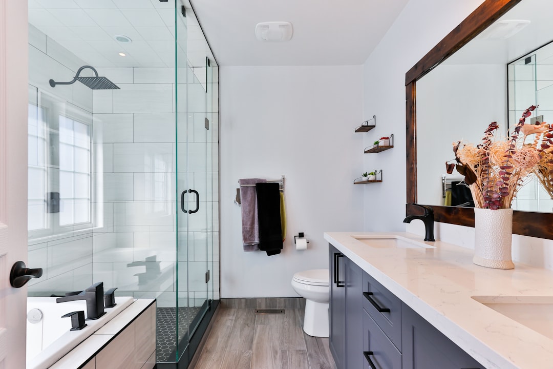 Salle de bain rénovée avec douche moderne, carrelage blanc et finitions soignées par B2M Services à Genève et Vaud