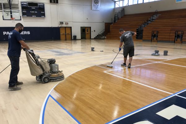 man resurfacing a basketball court 