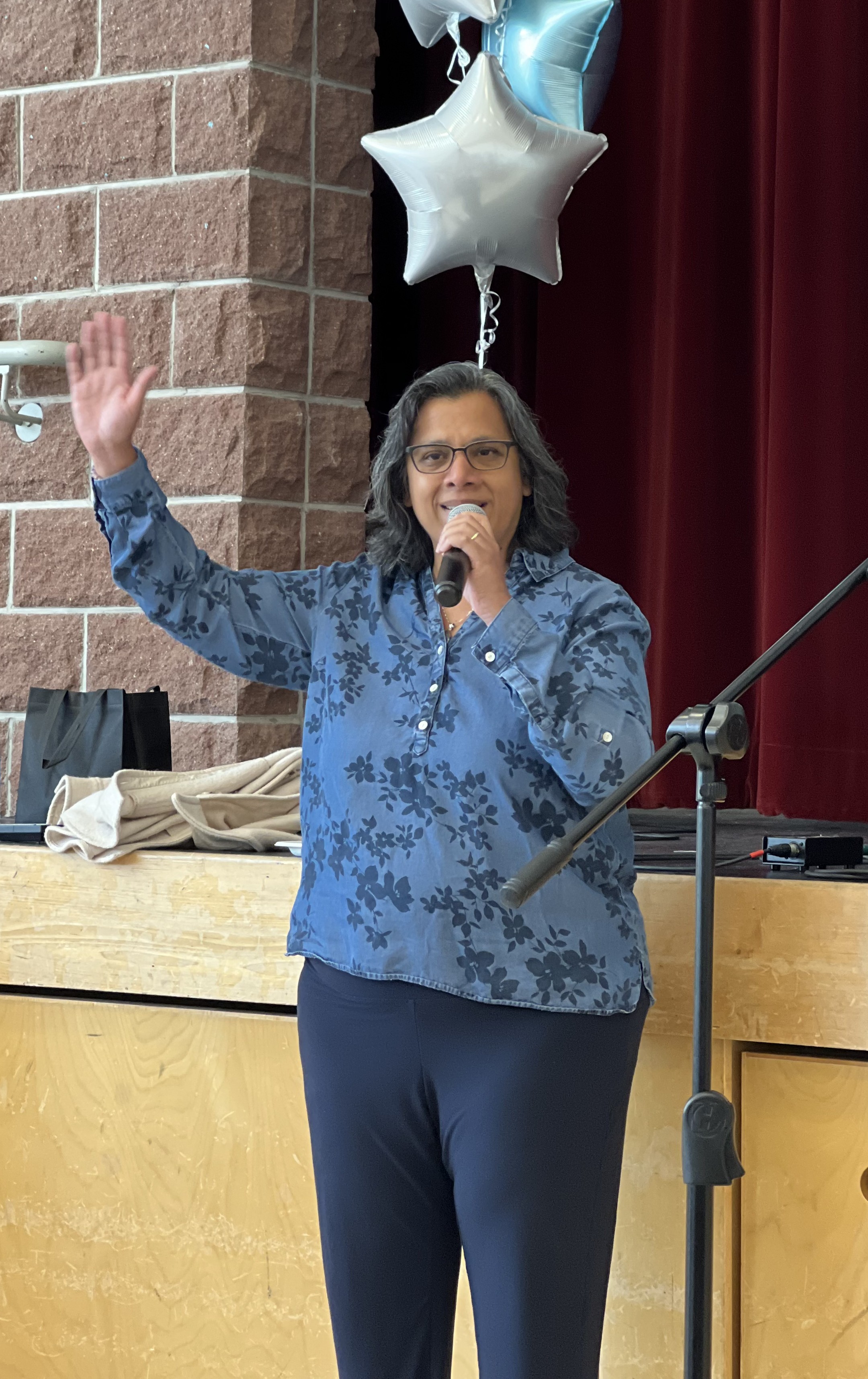 Julia speaking at a school event, mic in hand