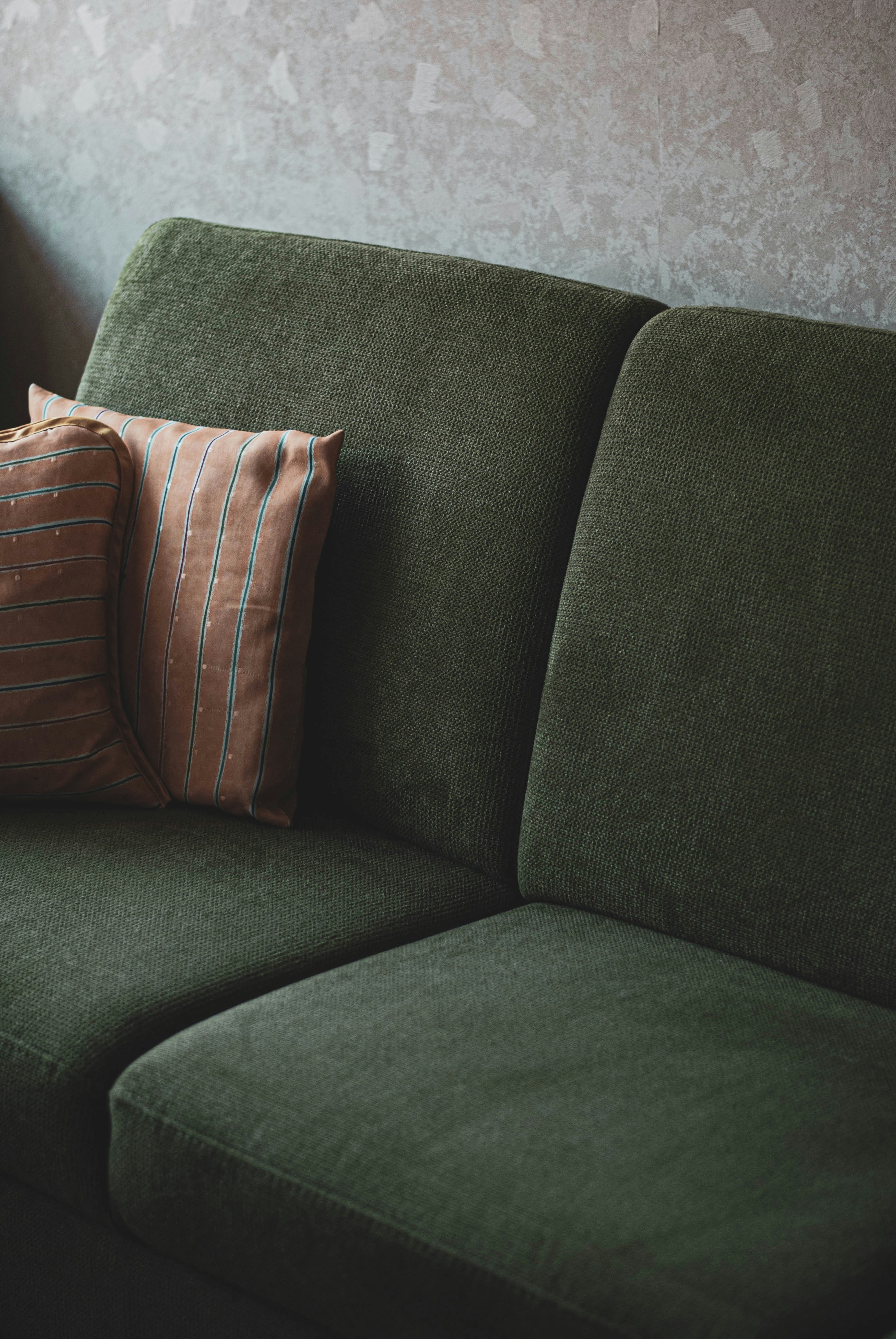 Groene bank met zachte stoffen in een rustig, prikkelarm interieur