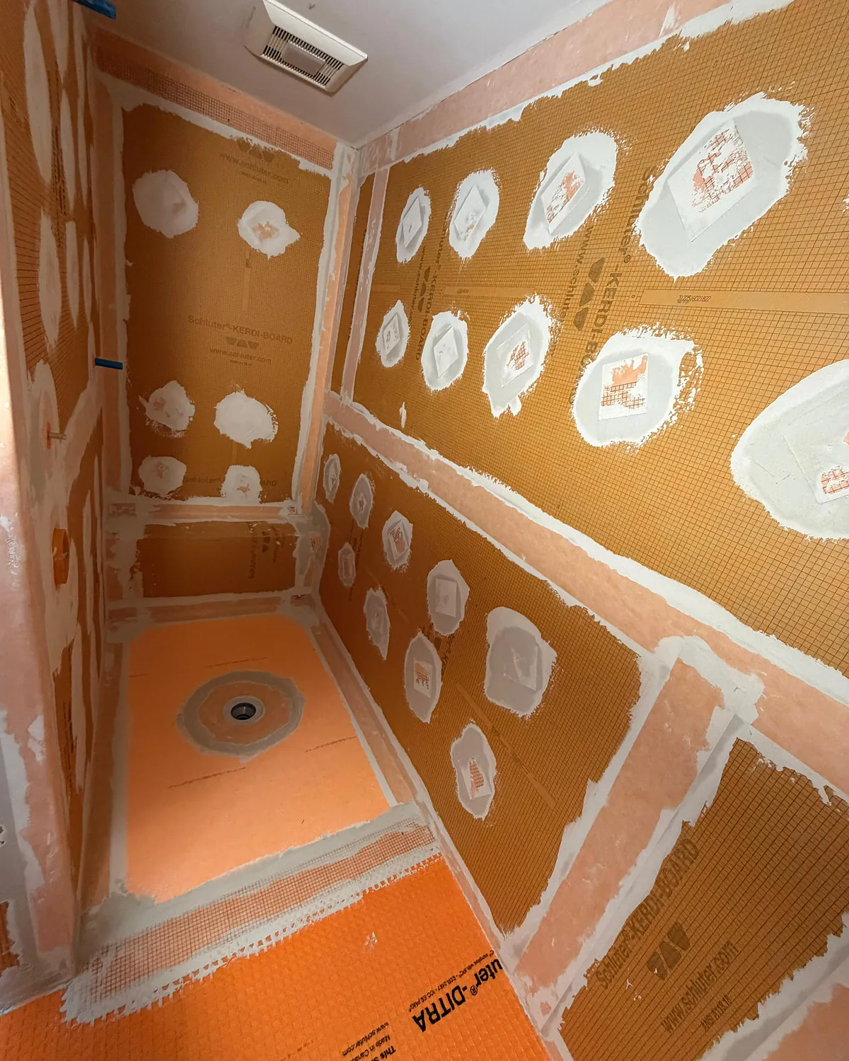 Shower walls and floor fully covered with a waterproofing membrane before tile installation