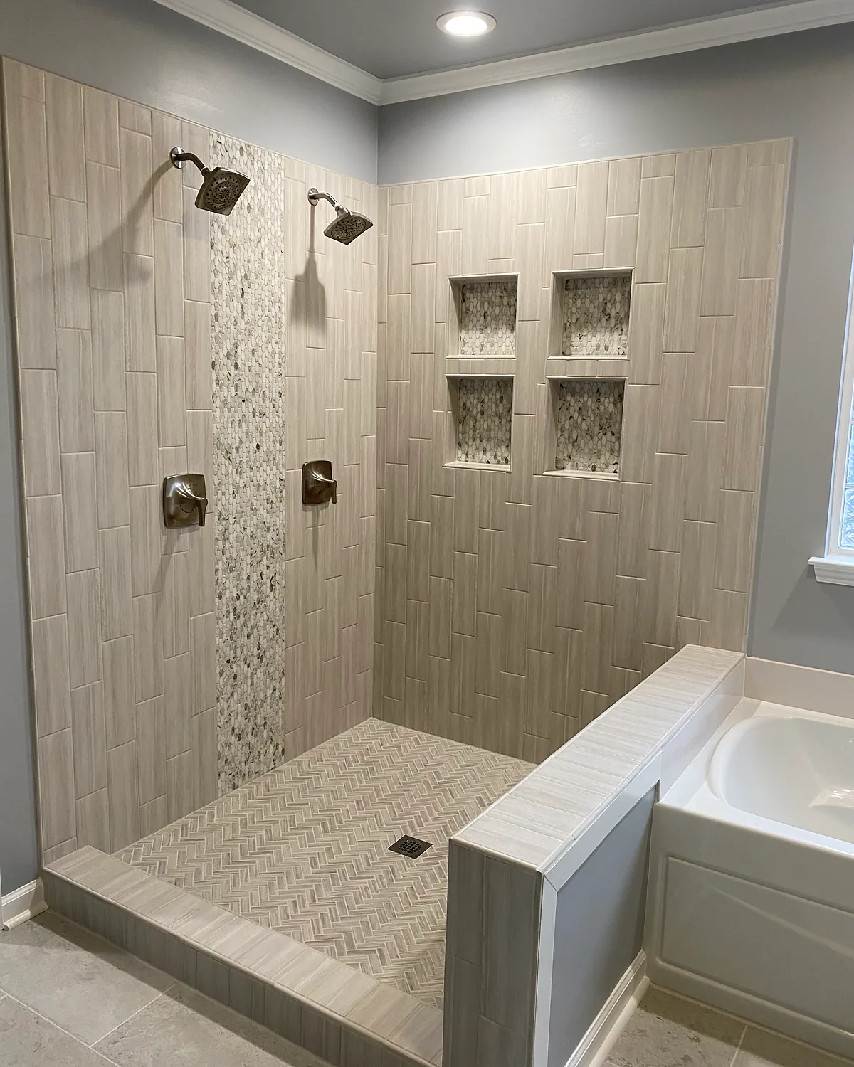 Walk-in shower with dual shower heads and recessed niches