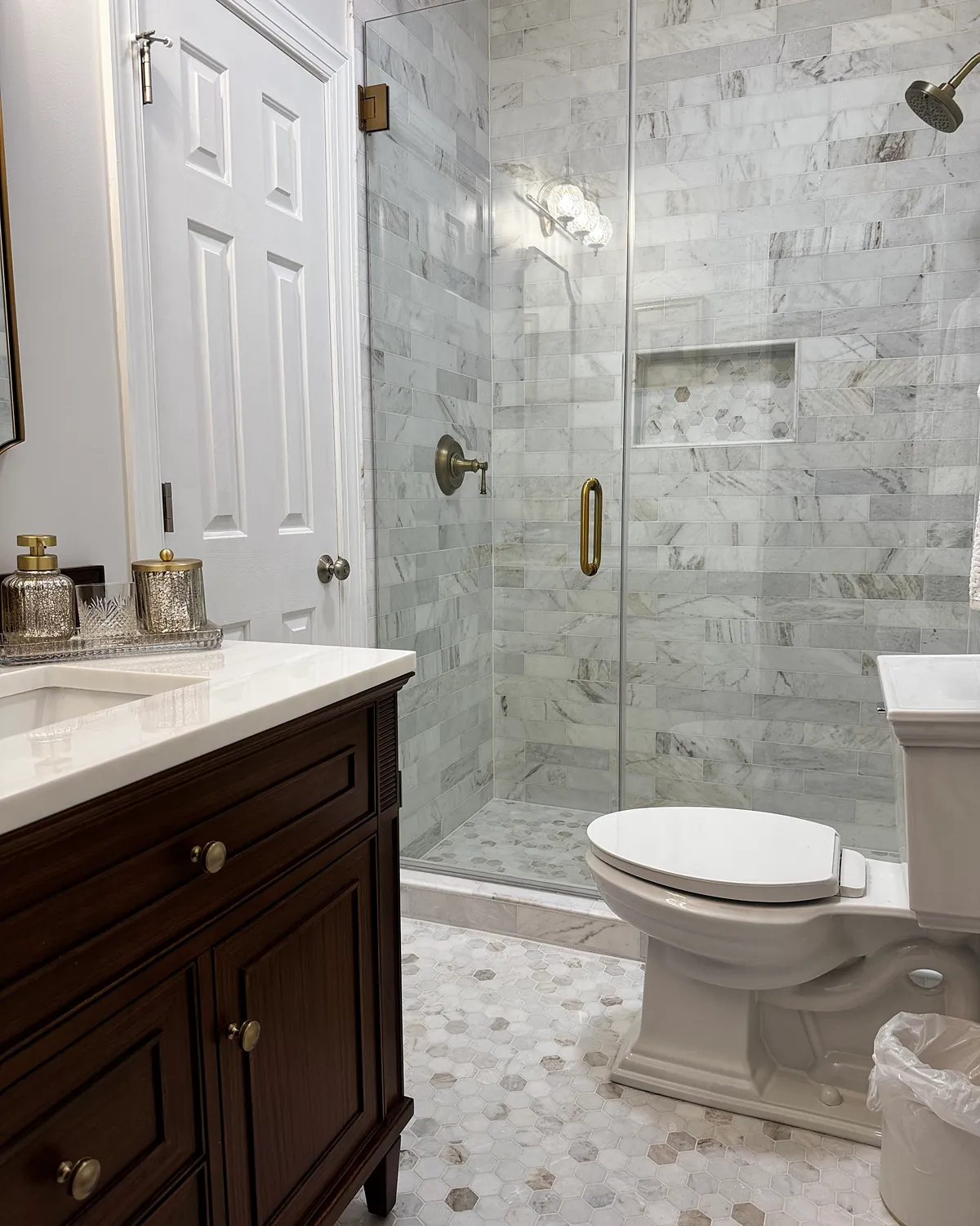 Walk-in shower with marble subway tile and a glass door