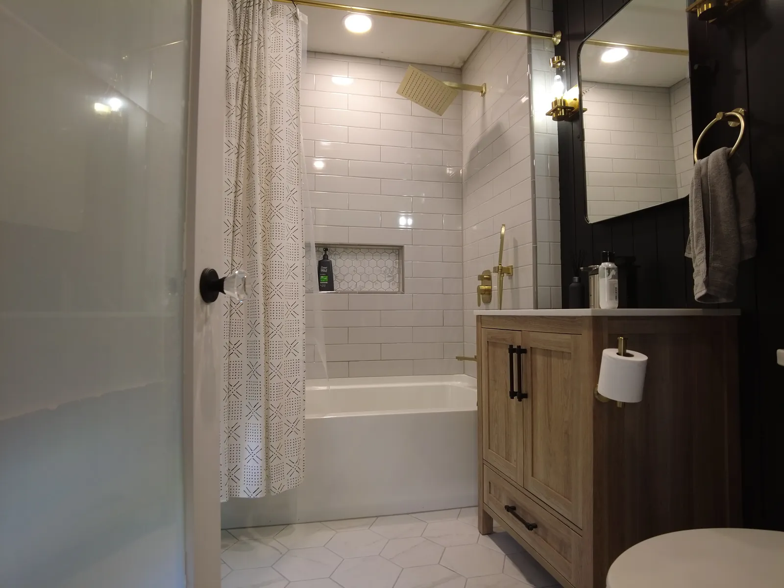 Bathroom with subway tile, brass fixtures, and a wood vanity