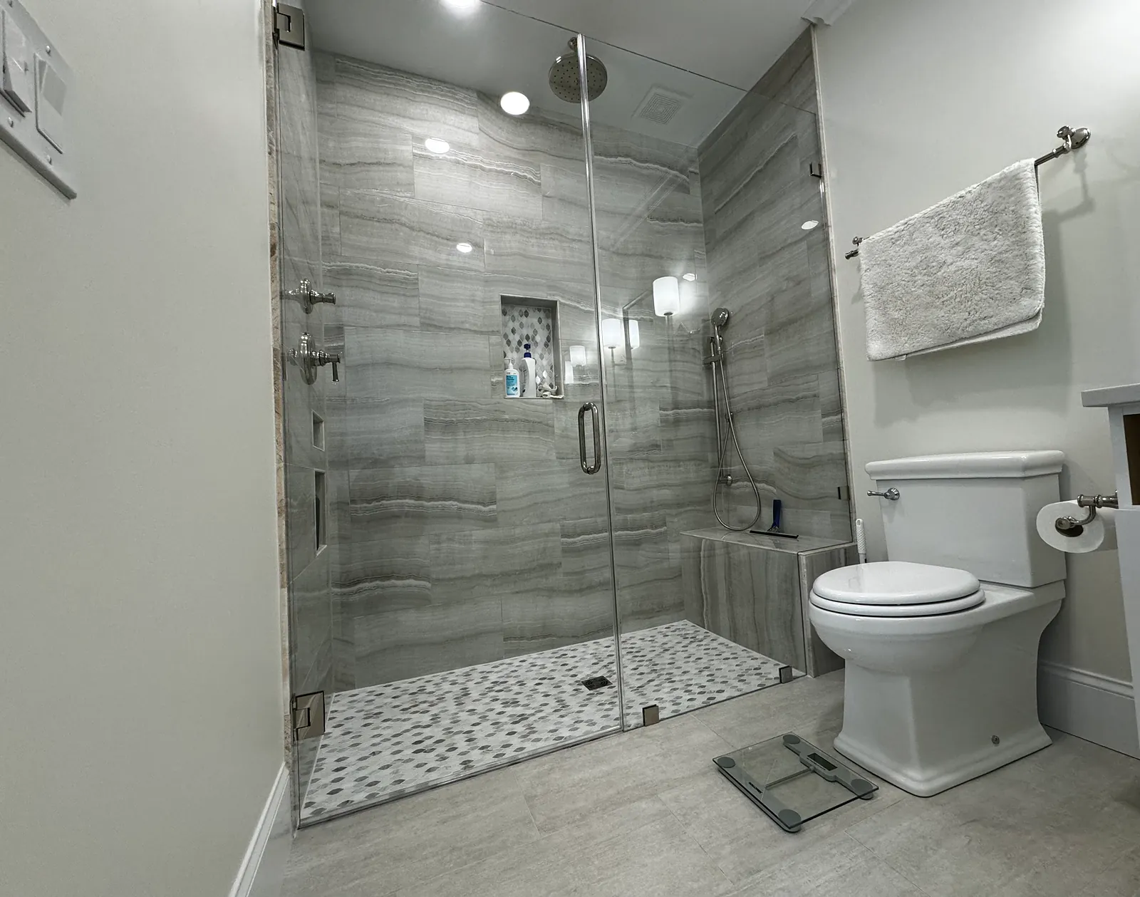 Walk-in shower with wood-look tile and a built-in bench