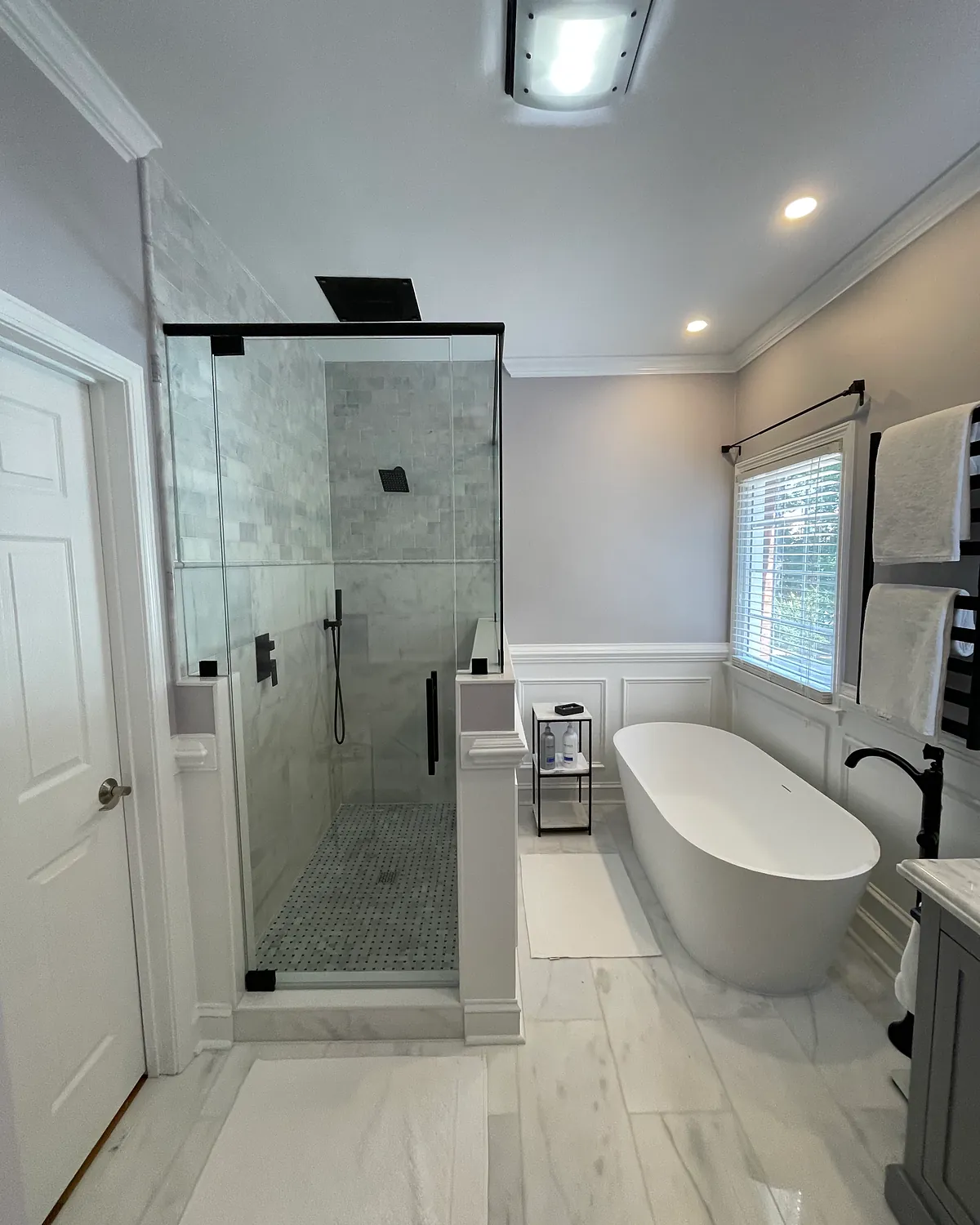 Bathroom with a black-frame glass shower and a freestanding tub