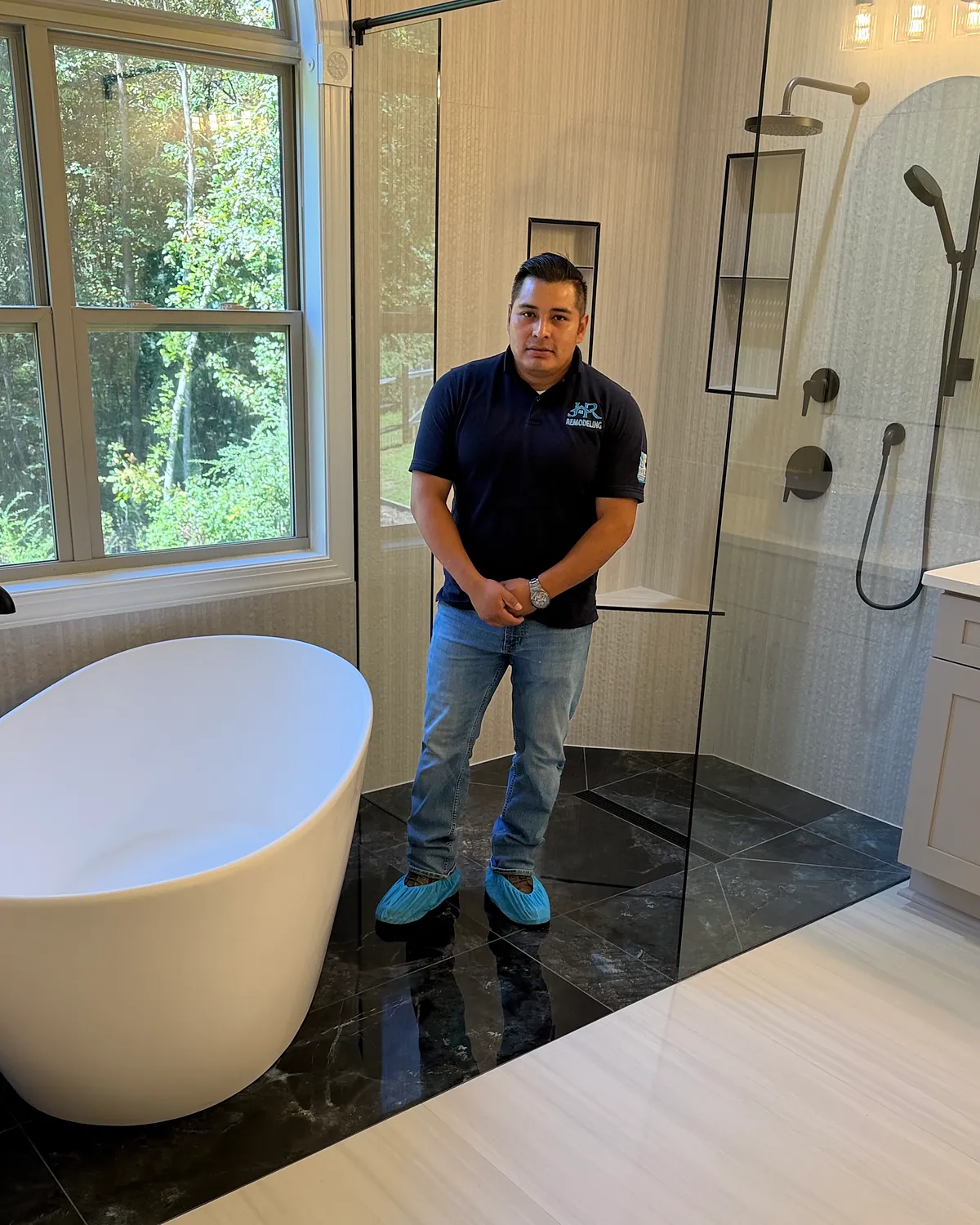 Carlos Rodriguez, owner of JR Remodeling, standing in a completed primary bathroom remodel