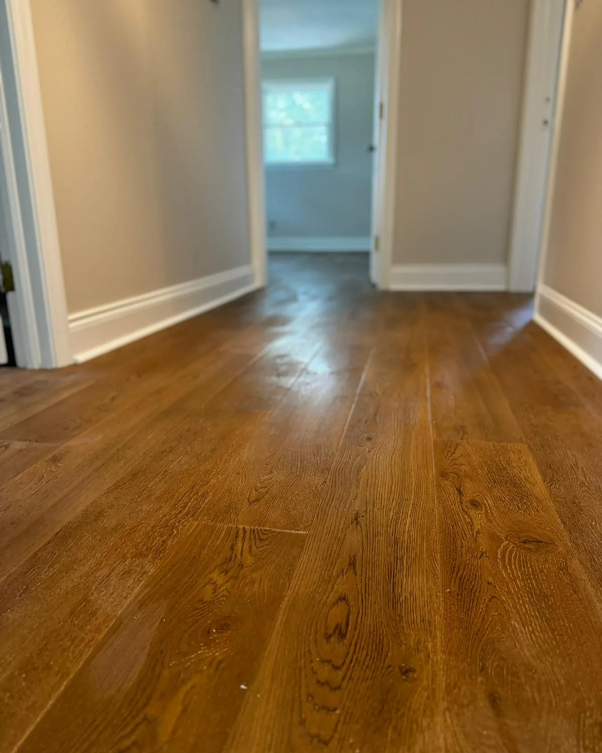 New hardwood flooring installed in a hallway during a home rebuild