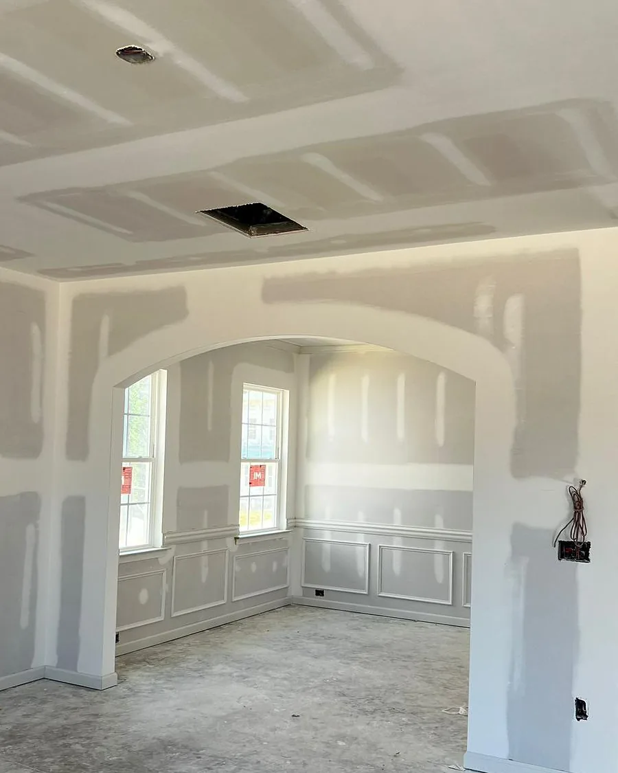Drywall and trim being rebuilt in a living area after property damage