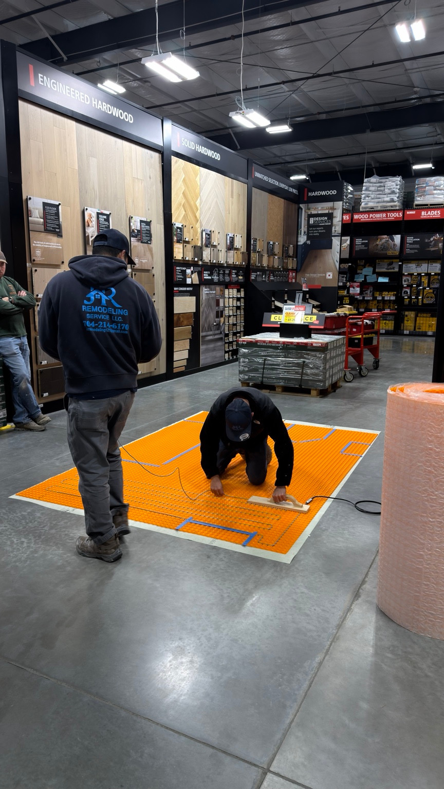 JR Remodeling team member at a hands-on floor-heating installation training demonstration.