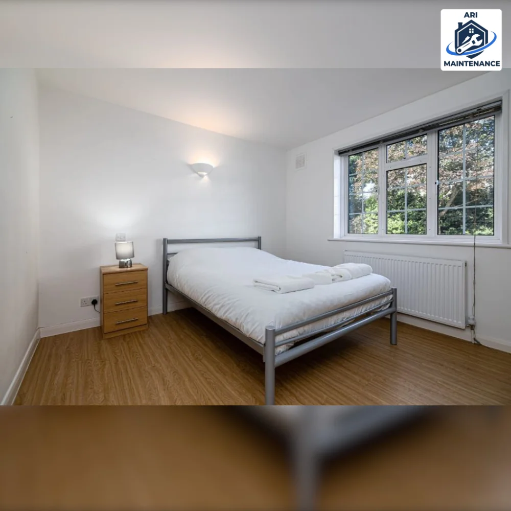 Refurbished bedroom with light wood flooring and double bed.