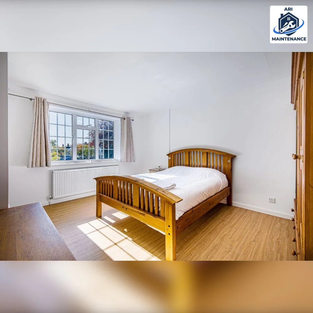 Refurbished bedroom with traditional wooden bed frame and oak floor.