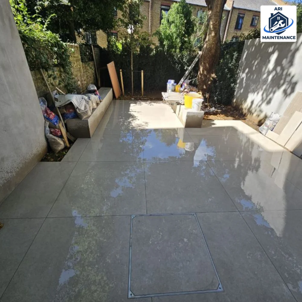 AFTER — same patio finished with concrete pavers, drainage covers in place.