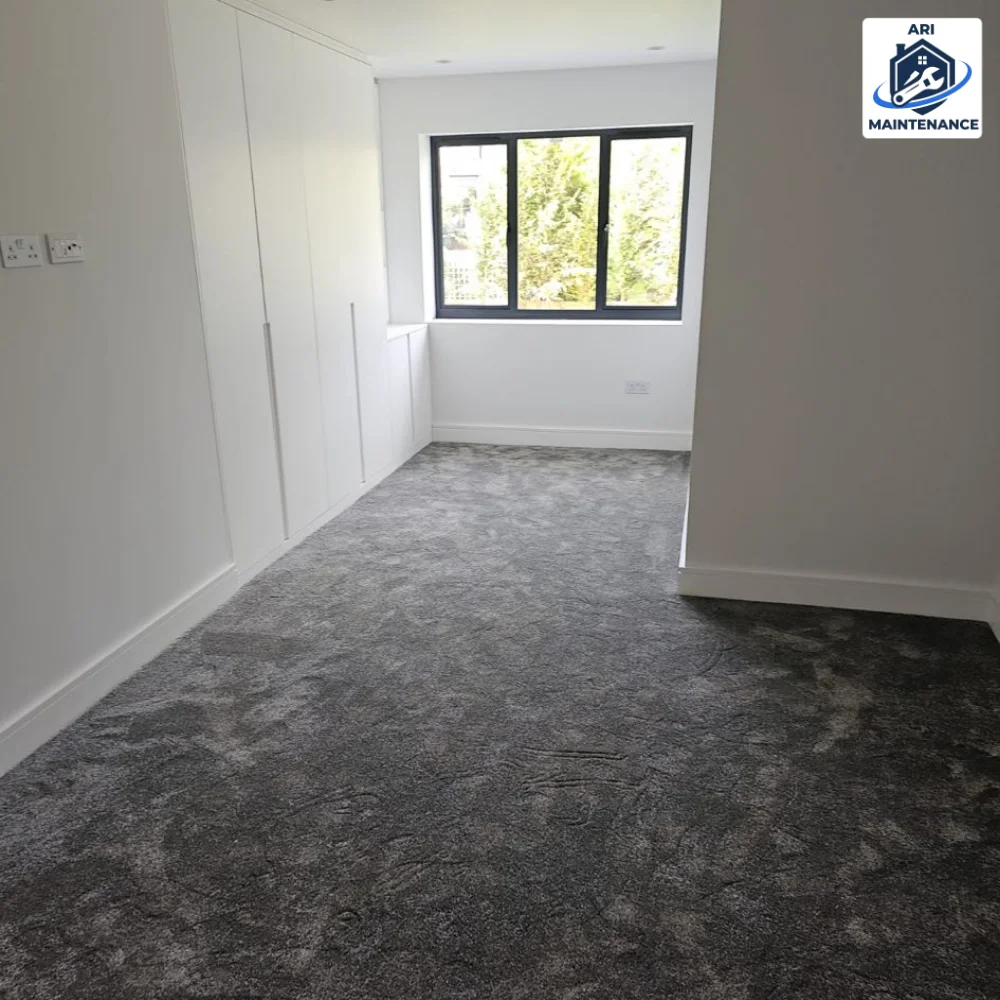 Refurbished bedroom with grey carpet and fitted wardrobes.